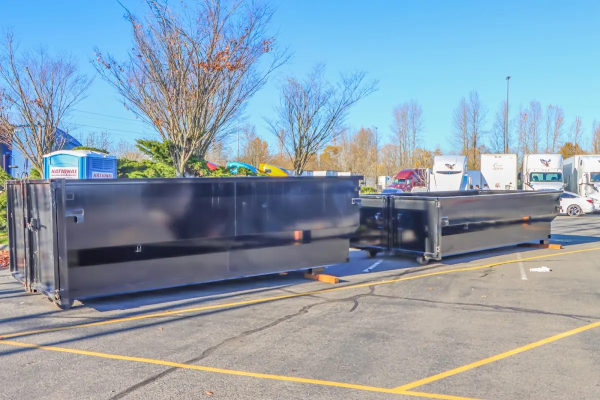 Professional dumpster rental service with roll-off container on residential driveway in Denville